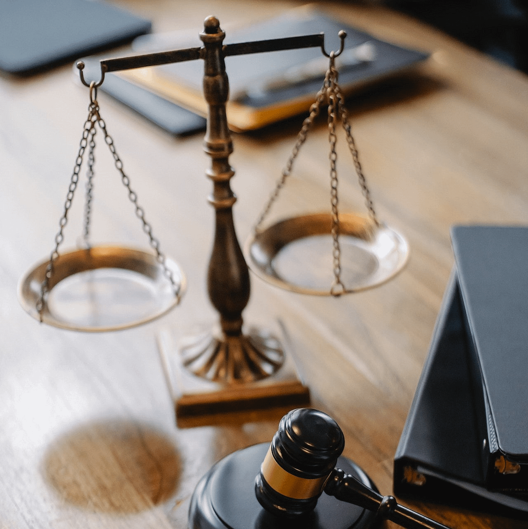 A scales of justice and a gavel on a wooden desk