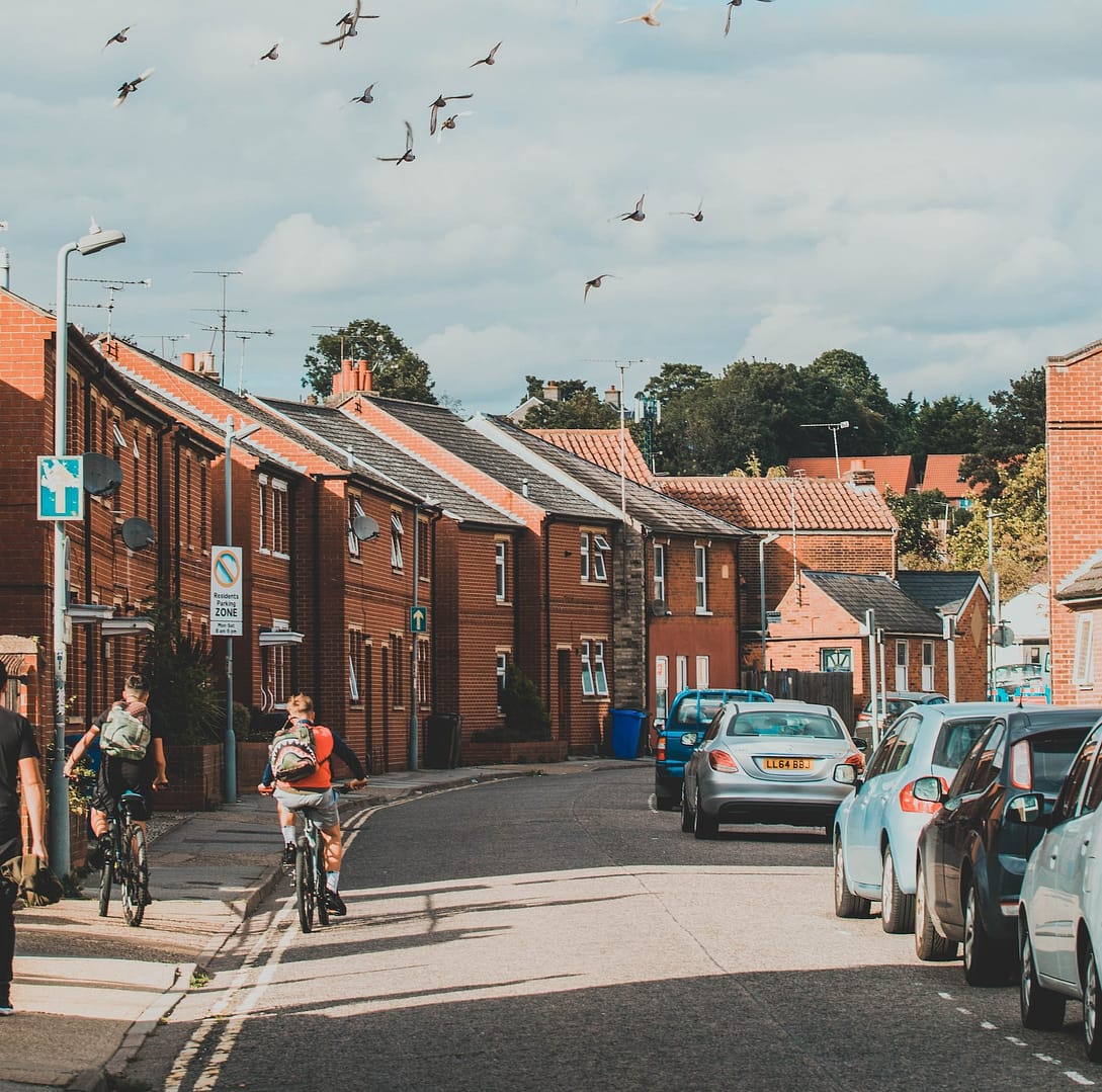 Two children on their bikes down a street