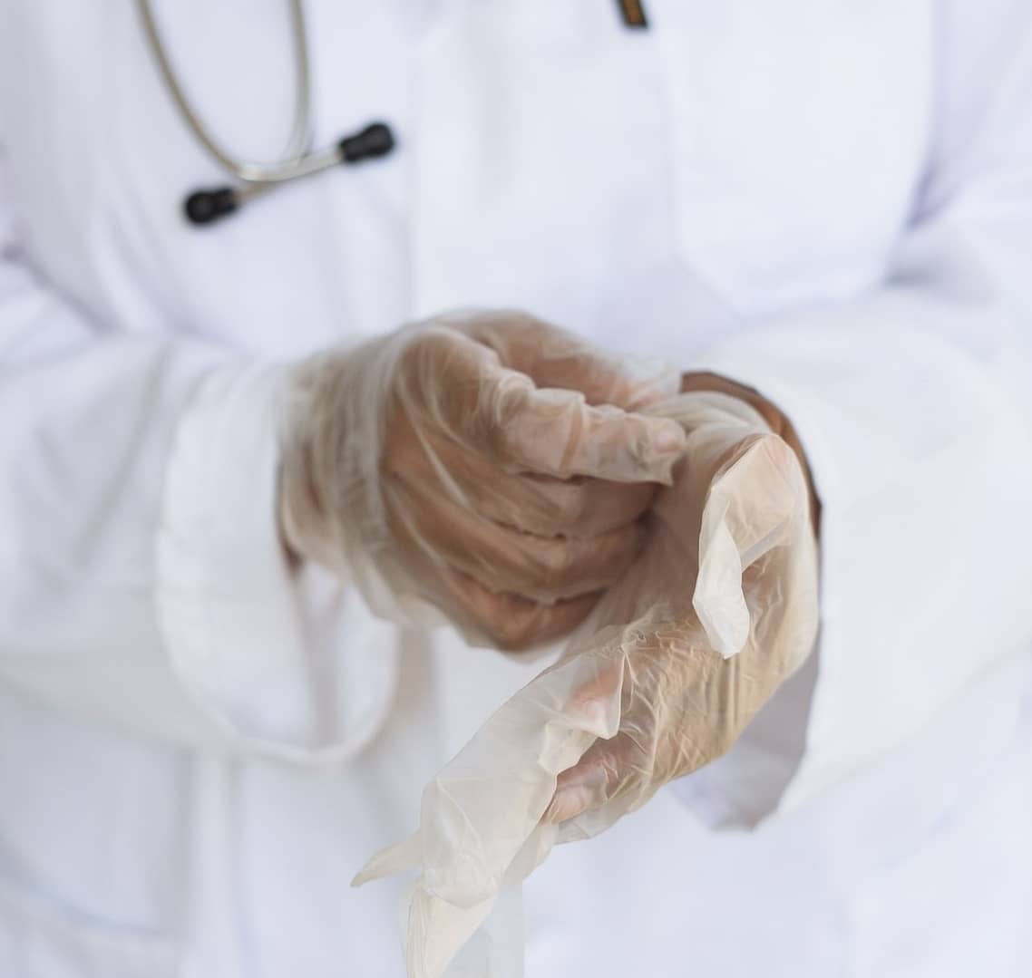 A doctor putting on gloves