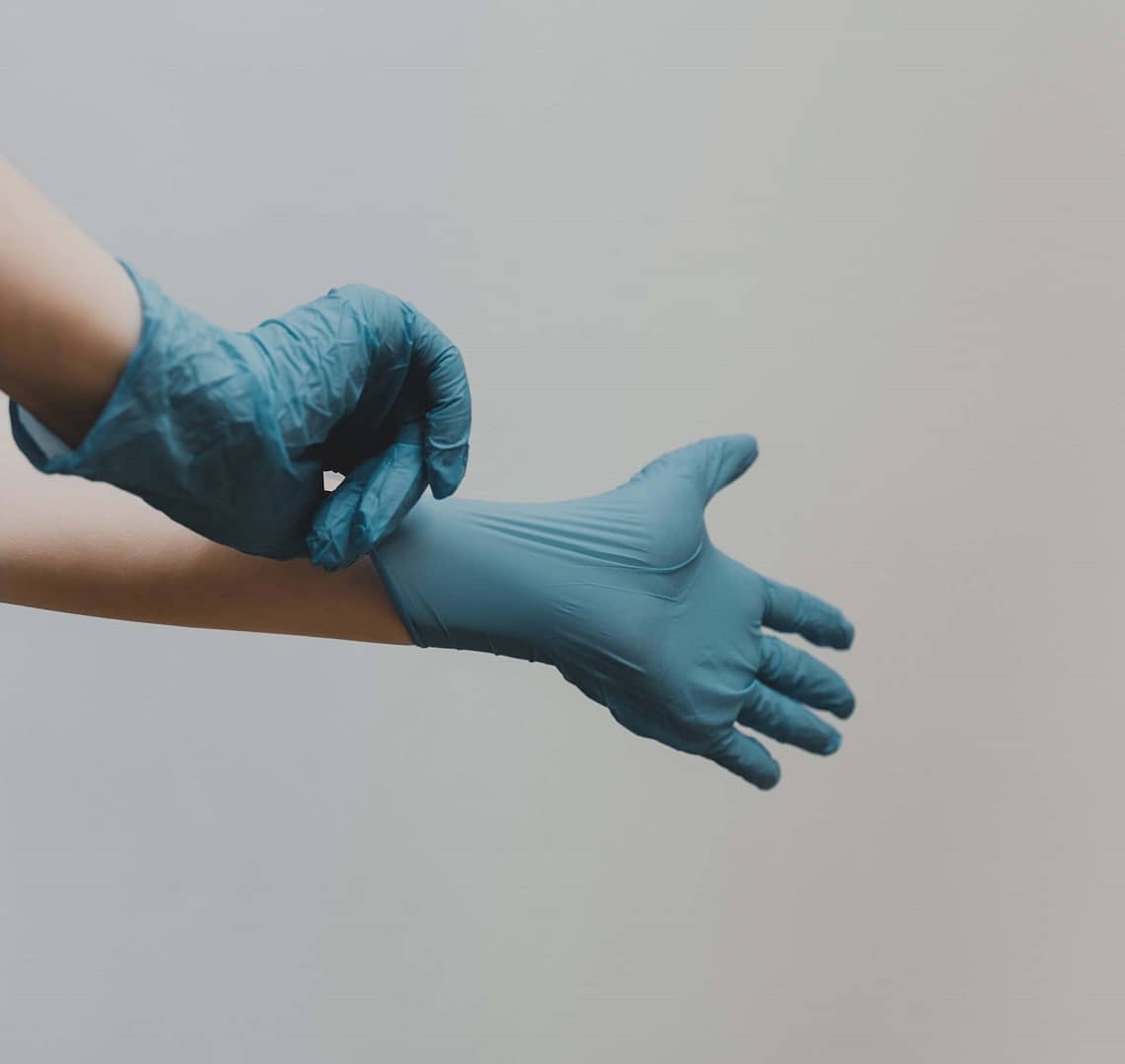A doctor putting on rubber gloves