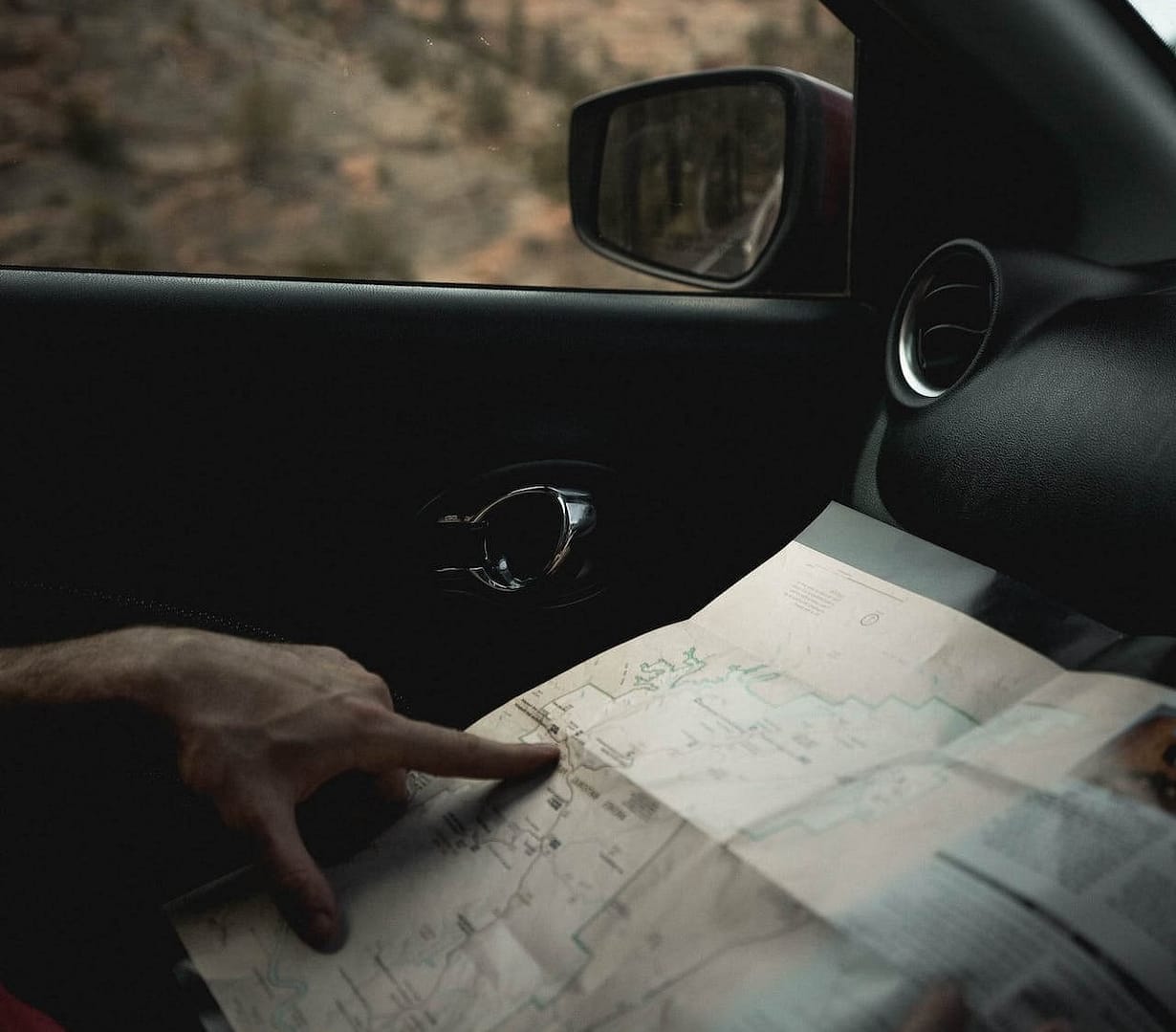 A car passenger looking at a map