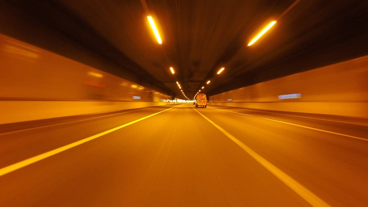 A well lit motorway under a tunnel