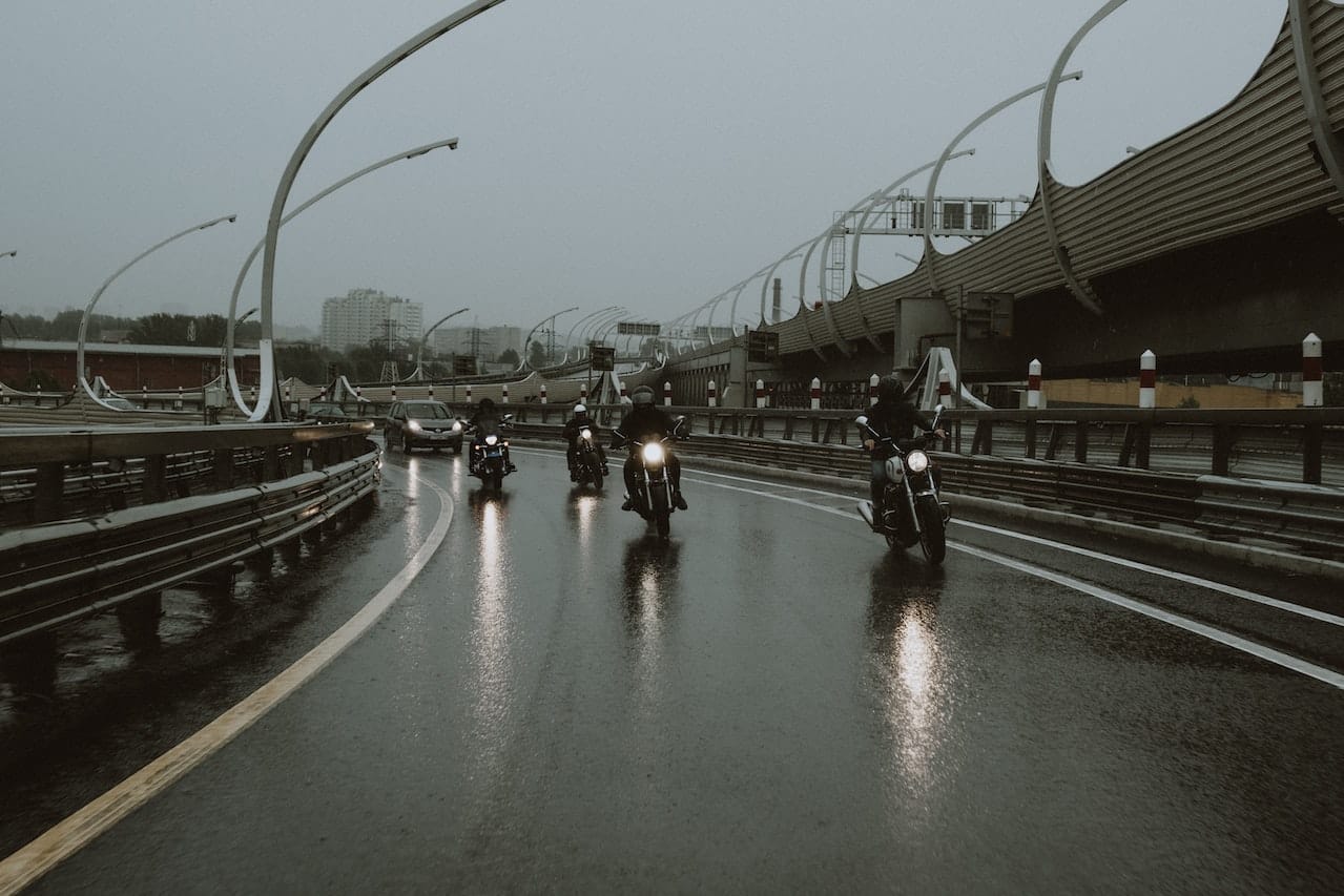 A group of motorbikes in front of a car on the motorway