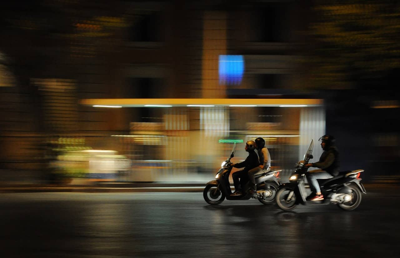 Two people riding on a moped