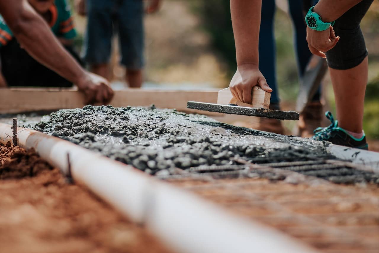 group of people working together laying foundations for building