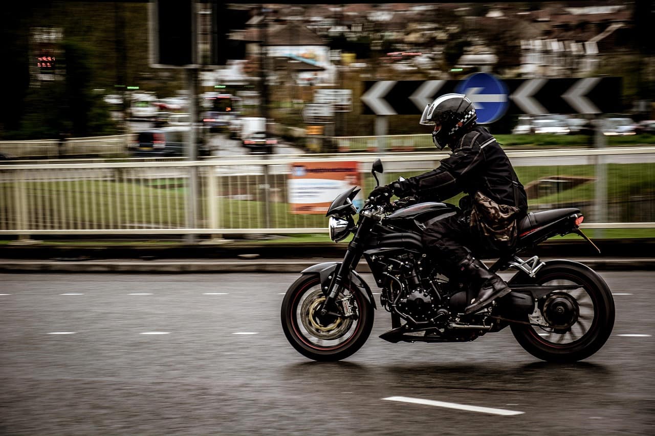 Someone on a motorbike riding around a roundabout