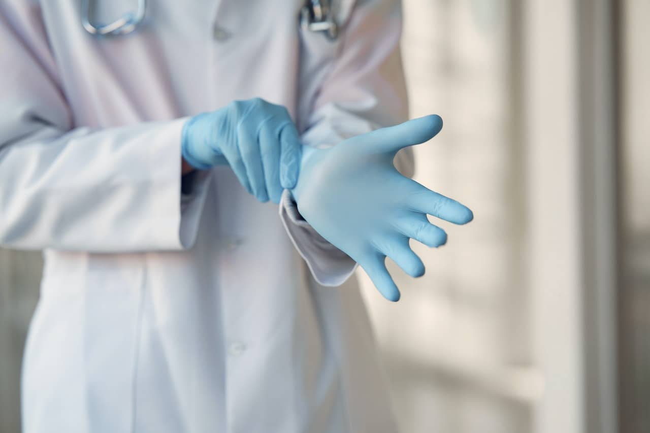 A doctor putting on rubber gloves