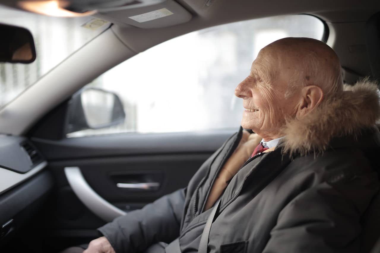 older person sat in a car