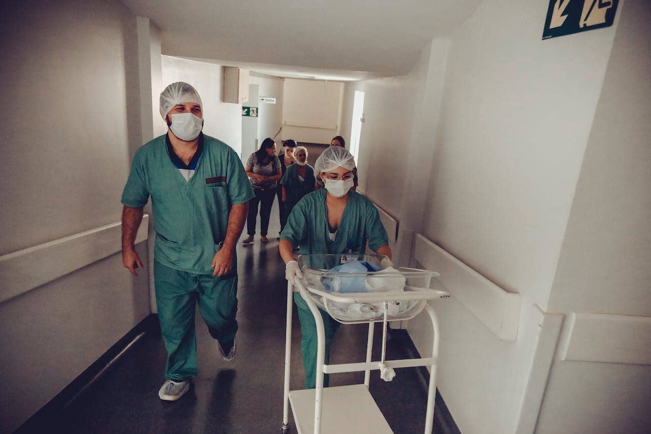 Nurses moving a baby through a hospital hall