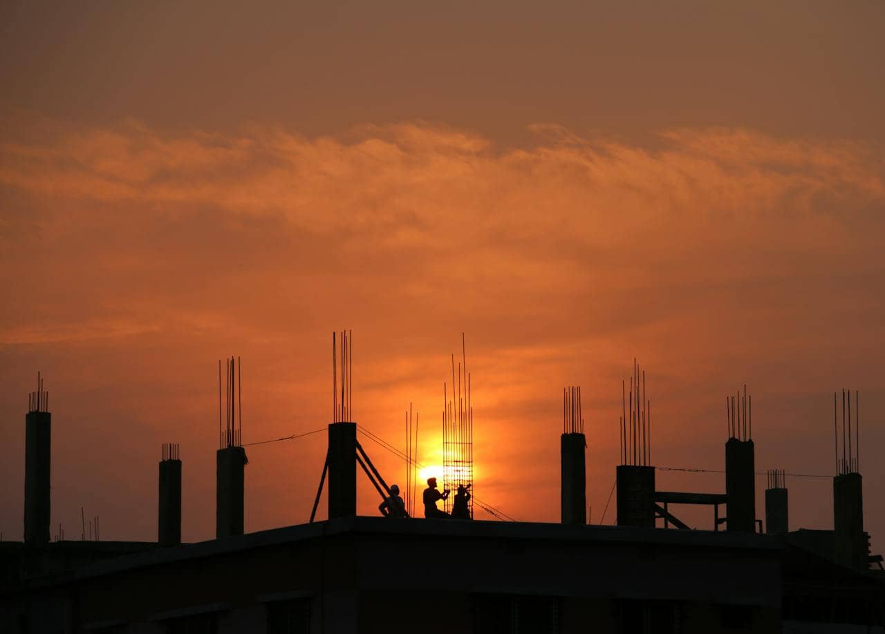 People working on a construction site at sunset