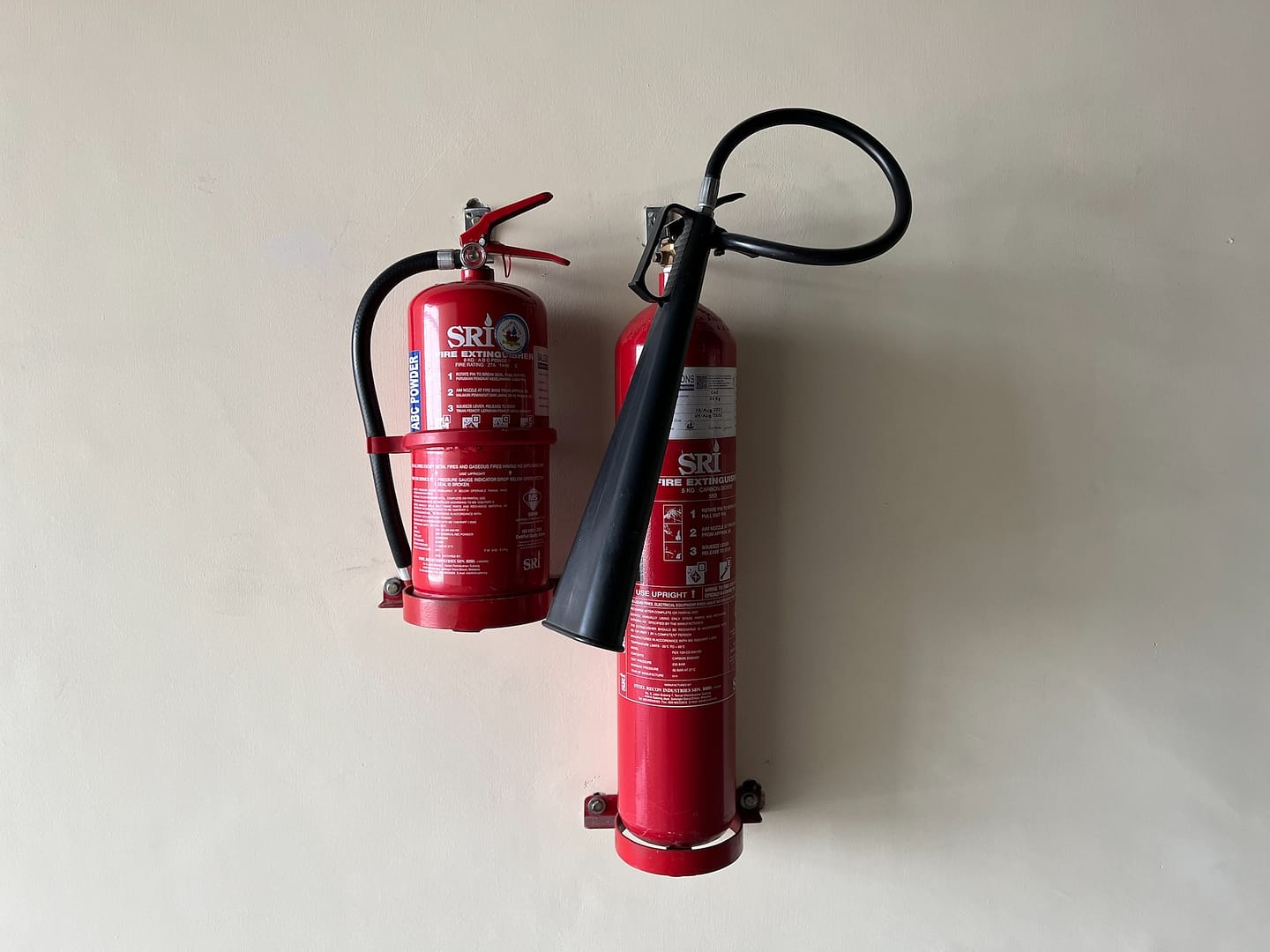 Two different fire extinguishers on a wall