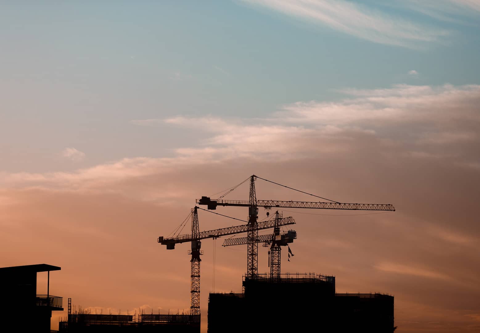 Three cranes at a construction site