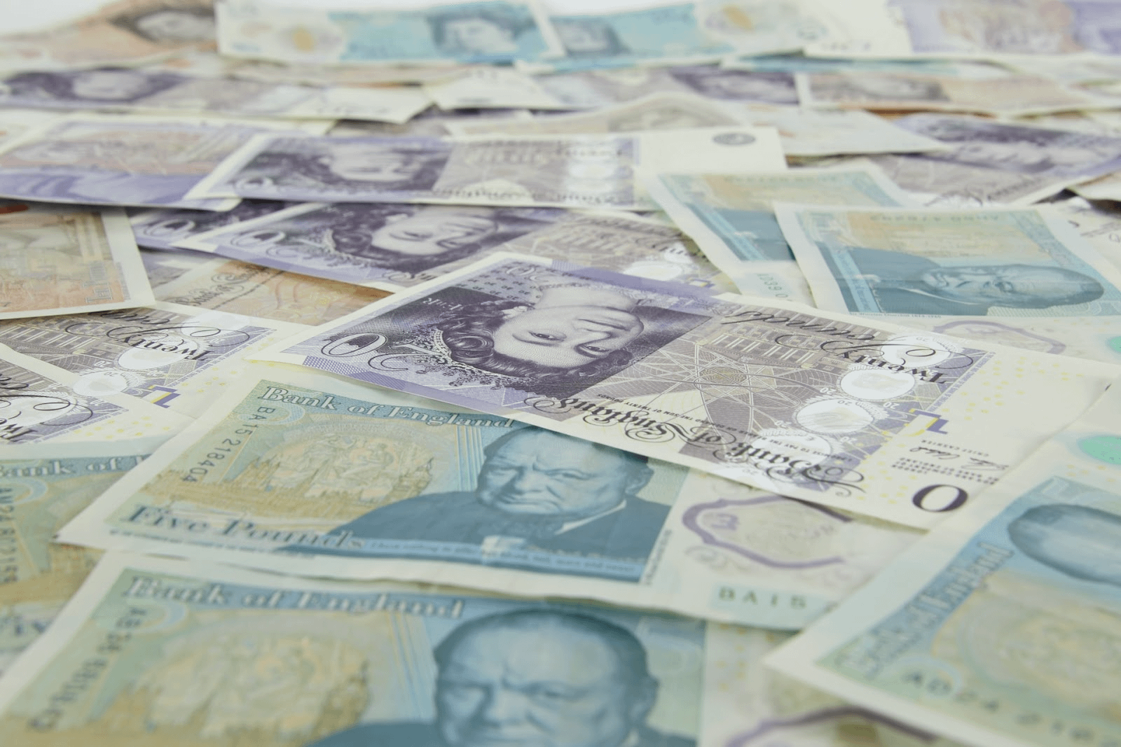 mixture of pound notes spread across a table