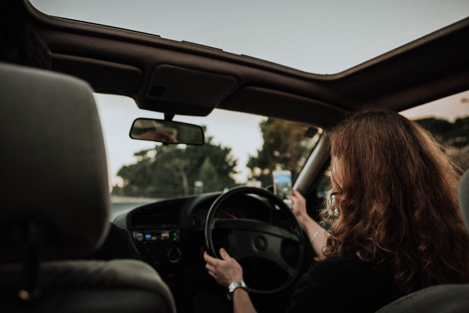 Someone behind the drivers seat of a car