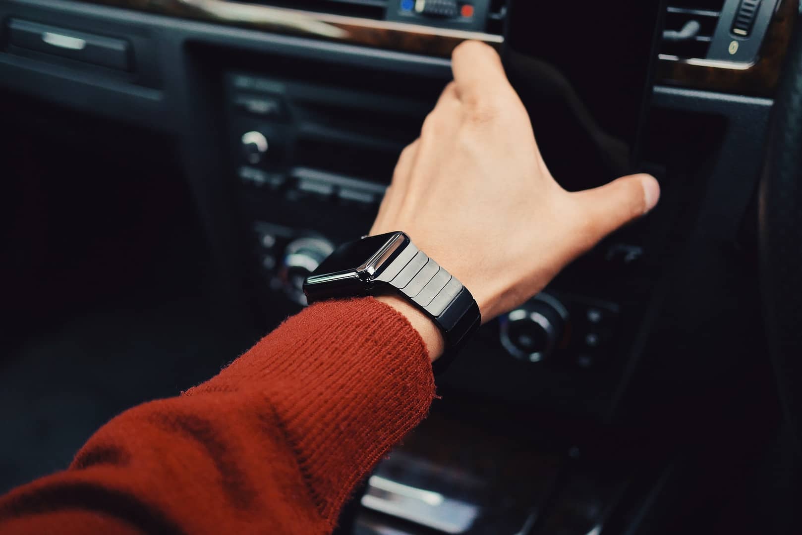 Someone in a car with a phone and smart watch