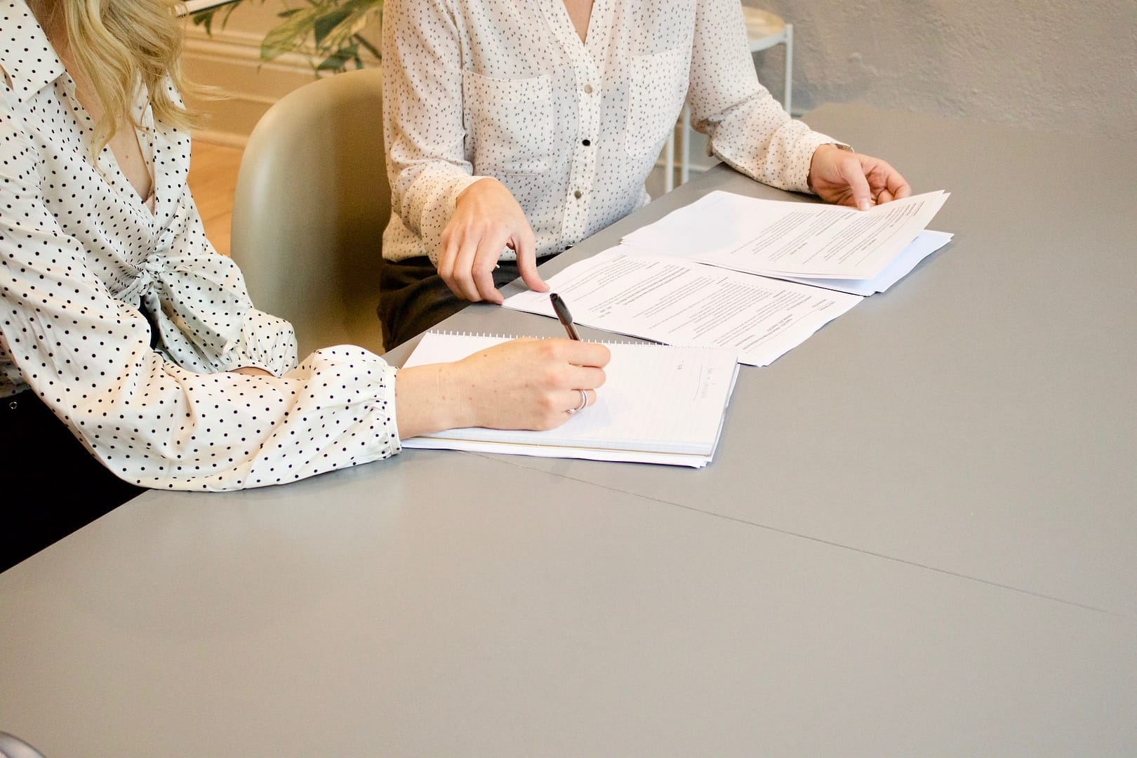 Two people perusing and signing paperwork