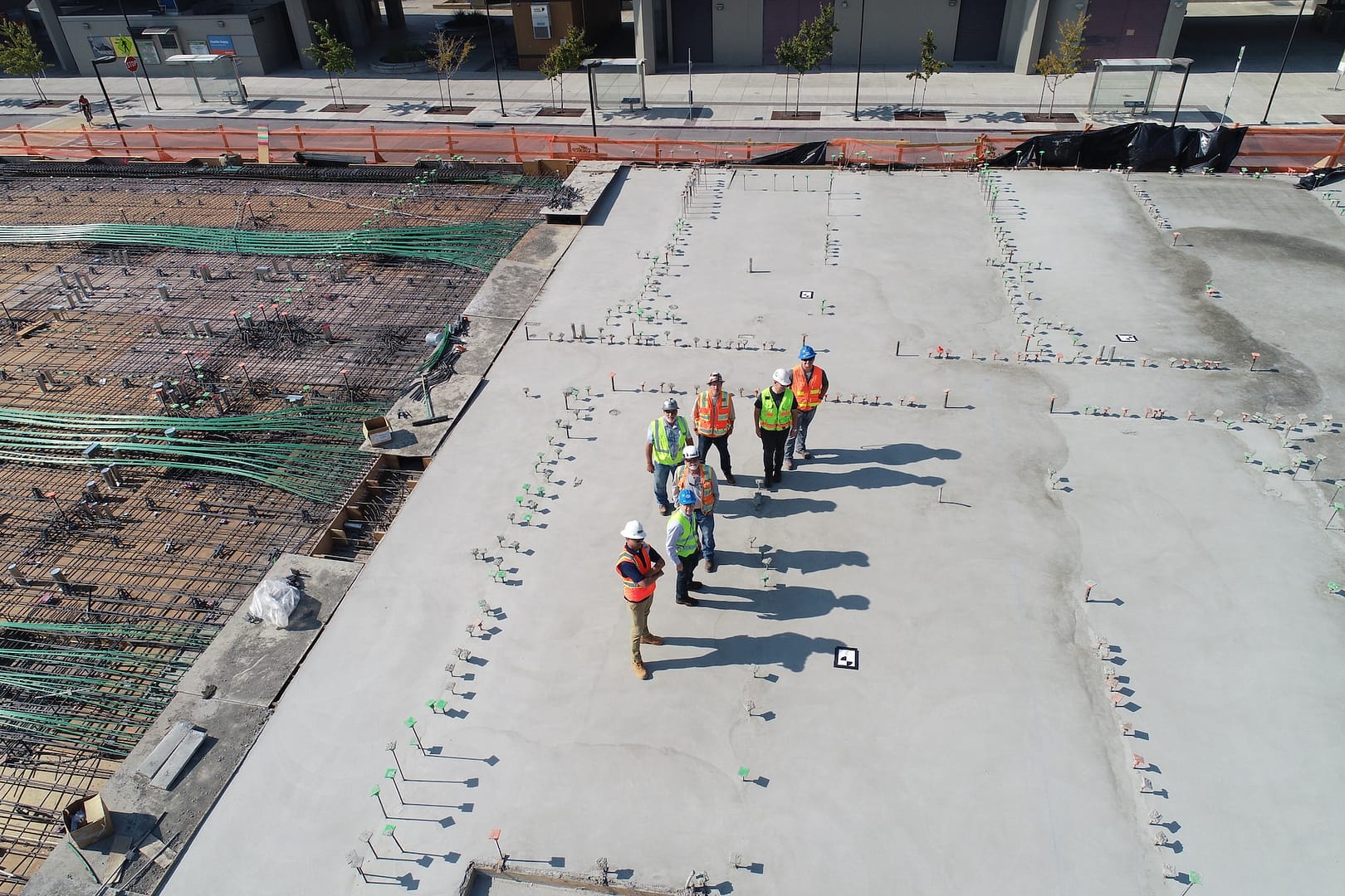 A group of people surveying a building site in protective gear