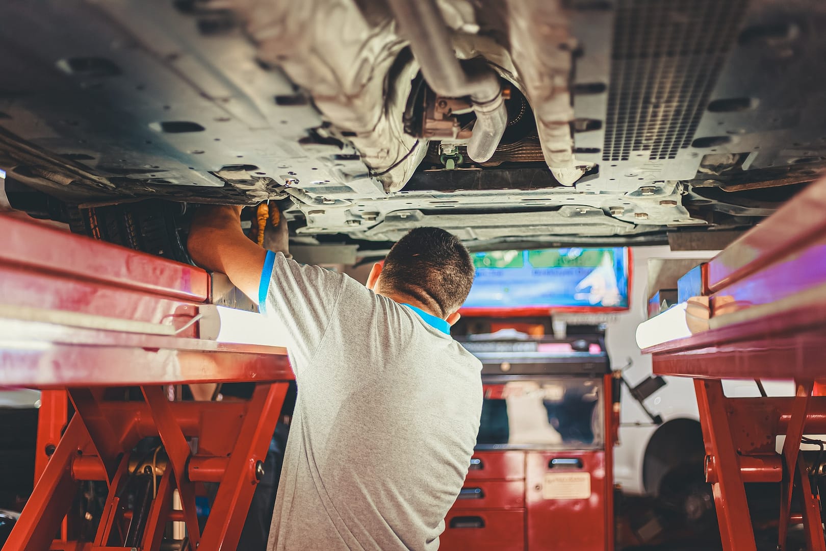 A mechanic underneath a car