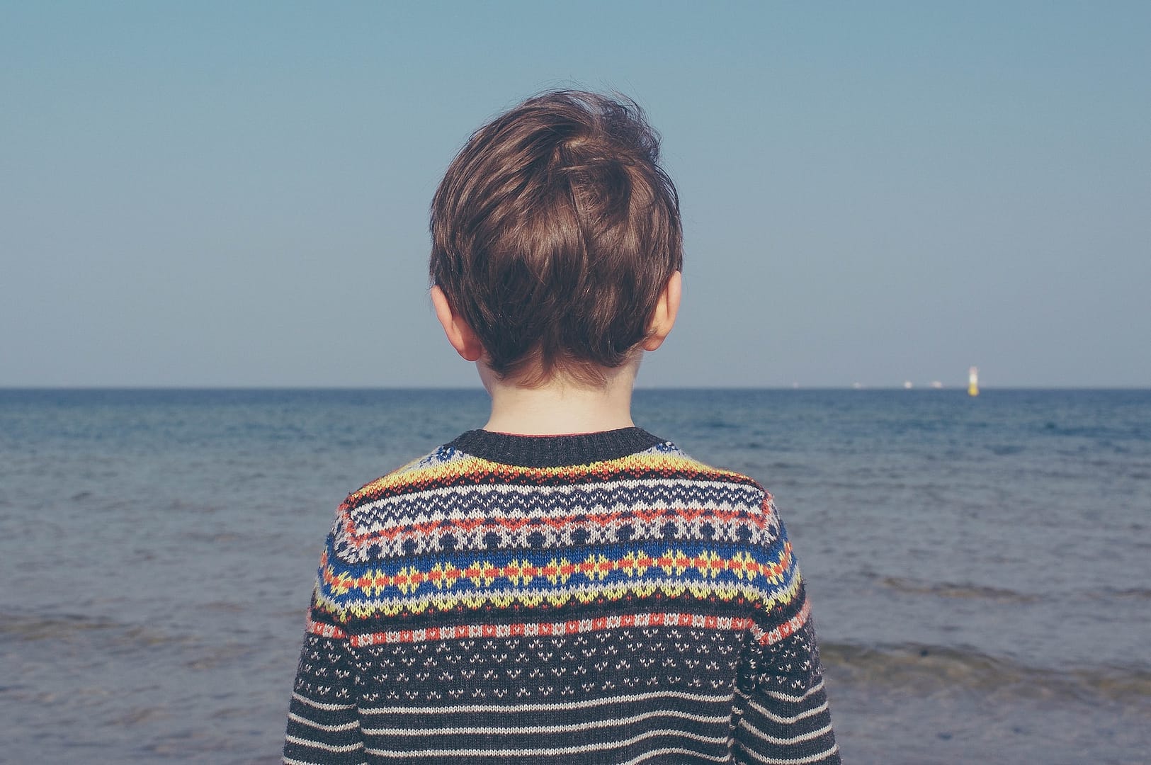 A child looking out to sea