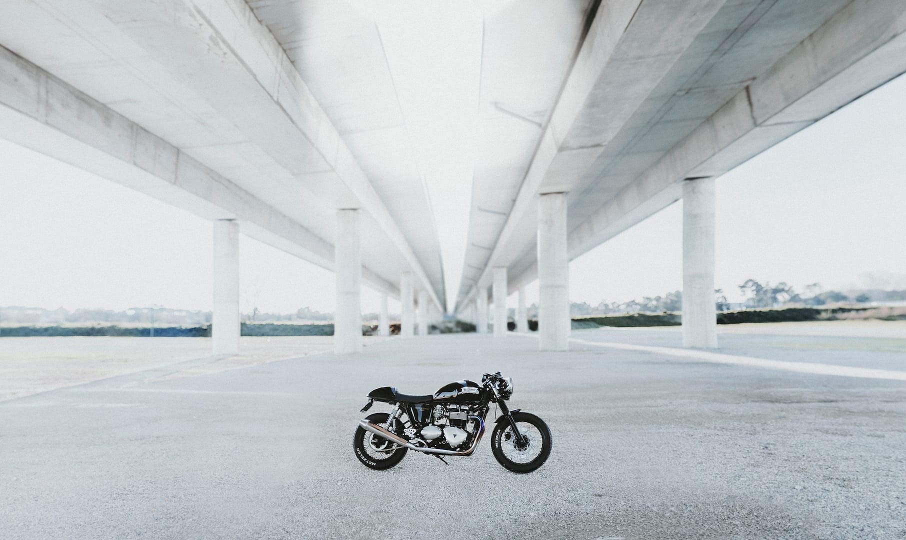 A motorbike parked under a bridge