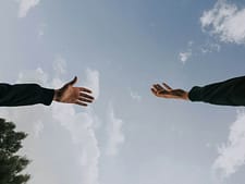 Two people reaching out their hands