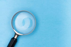 A large magnifying glass against a blue background