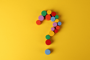 A multicoloured question mark against a yellow background