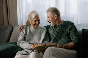 an elderly couple flicking through a book