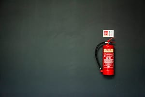 A red fire extinguisher against a dark wall