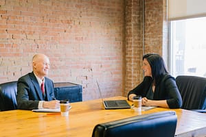 Two people sat across each other at a desk