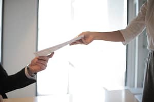 someone handing paperwork to a collegue