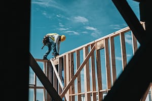 A builder standing on a wooden frame