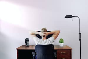 Someone stretching in their chair at their desk