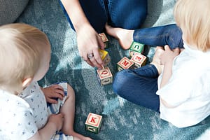 Two children playing with wooden blocks