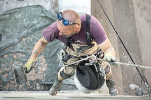 Someone harnessed painting a wall