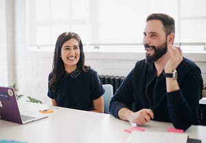 two colleagues laughing at work