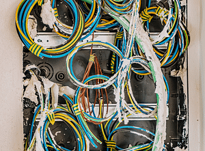 a number of coloured electrical wires inside a wall