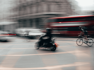 A moped riding alongside a cyclist