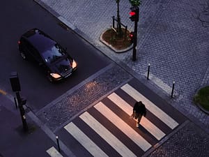 A car waiting for a pedestrian to cross the street