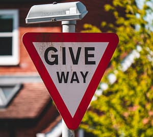 A 'give way' road sign in front of a house