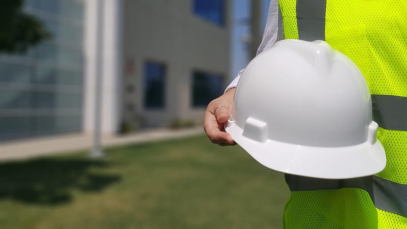 Someone in hi vis holding a hard hat