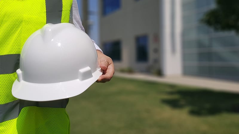 Someone in a hi vis jacket holding a hard hat