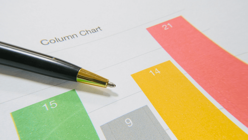 Printed multi-coloured bar graph with a black pen resting on top of the page