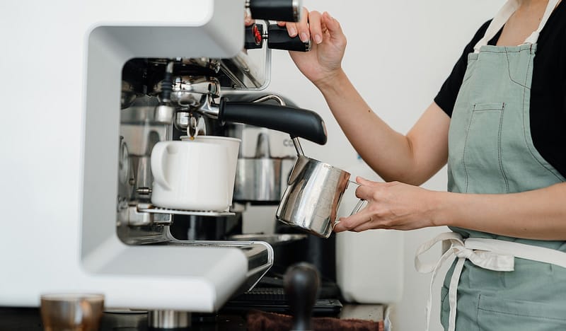 woman steaming milk in a coffee shop