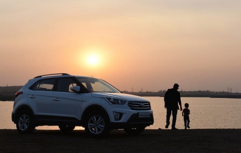 Parent and child next to a car