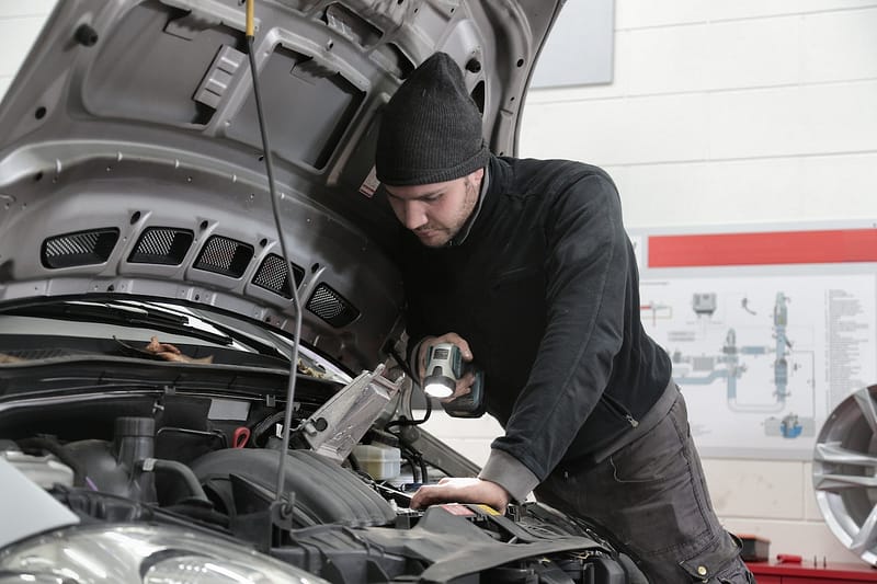 Mechanic inspecting car engine