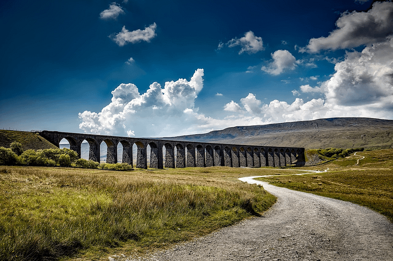 a rural UK road with a bridge in the background