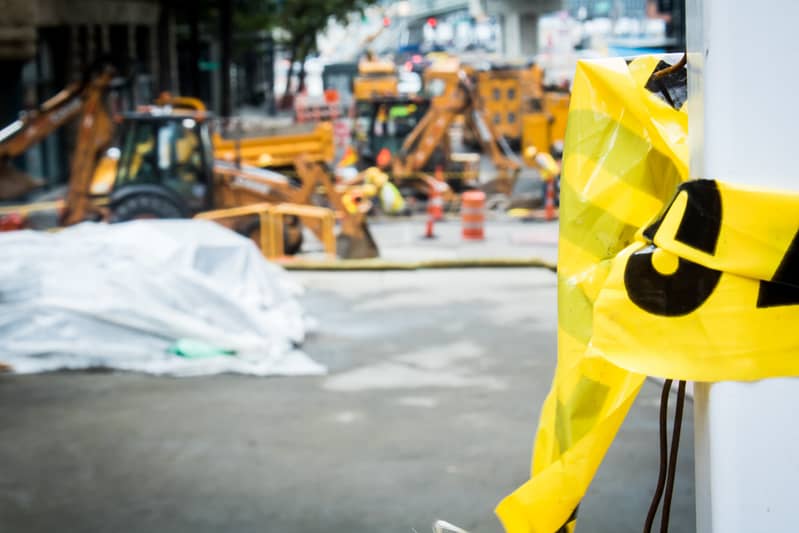 Construction site with ripped 'caution' tape in the foreground