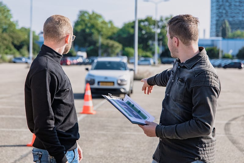 Two people looking in a car park