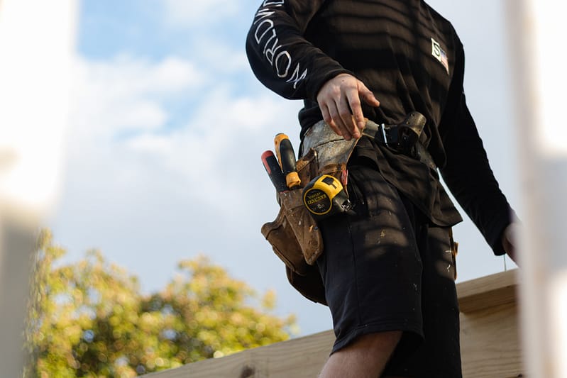 A builder with their tools in a belt